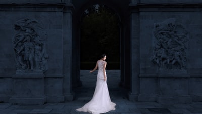 女人穿着白色无袖婚纱身体面临向建筑虽然看起来侧面
